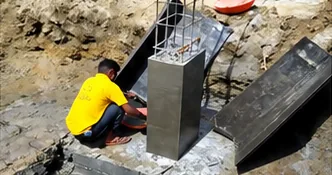 Worker fixing formwork around a column footing